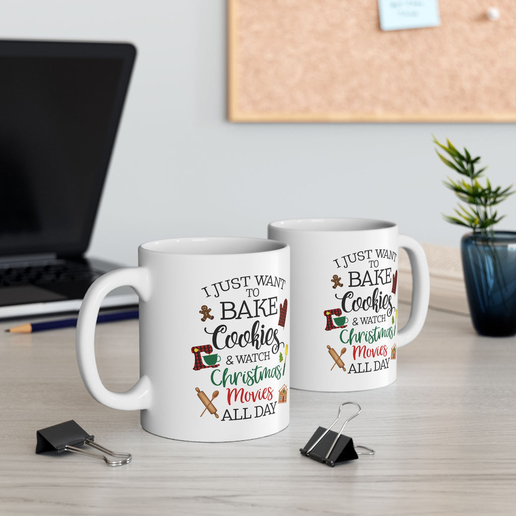 Two mugs with festive Christmas text on a desk with office supplies and a plant. Bake Cookie Coffee Mug, Watching Christmas Movies Coffee Mug