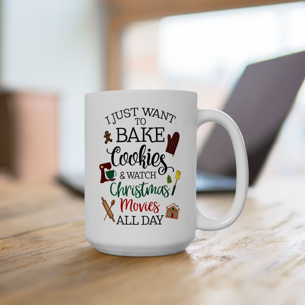 White ceramic coffee mug with the quote “I just want to bake cookies and watch Christmas movies all day,” featuring festive holiday icons like a gingerbread man, oven mitt, rolling pin, and gingerbread house.